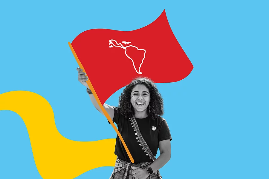 Fotografía en blanco y negro de una joven levantando una bandera con el mapa de América Latina, sobre fondo azul.