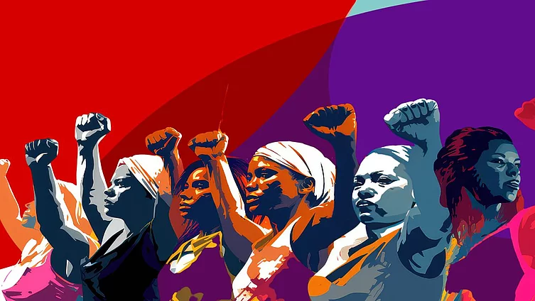 Grupo de mujeres diversas con sus brazos en alto, en actitud de lucha y defensa de sus derechos